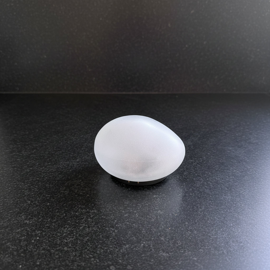 Frosted solar stone light shown unlit, with the natural texture and shape of a real river stone